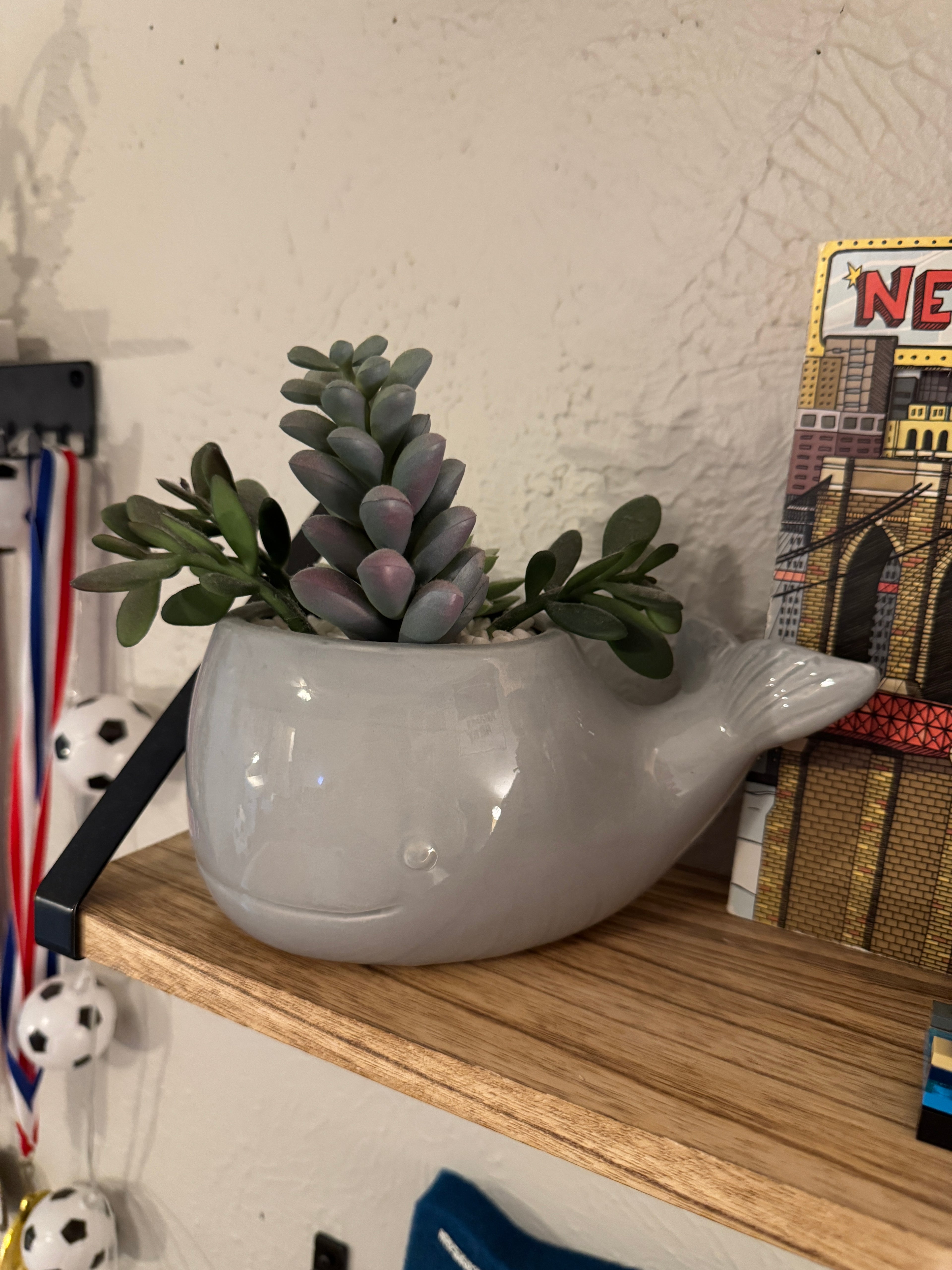 Faux plant in a gray ceramic whale